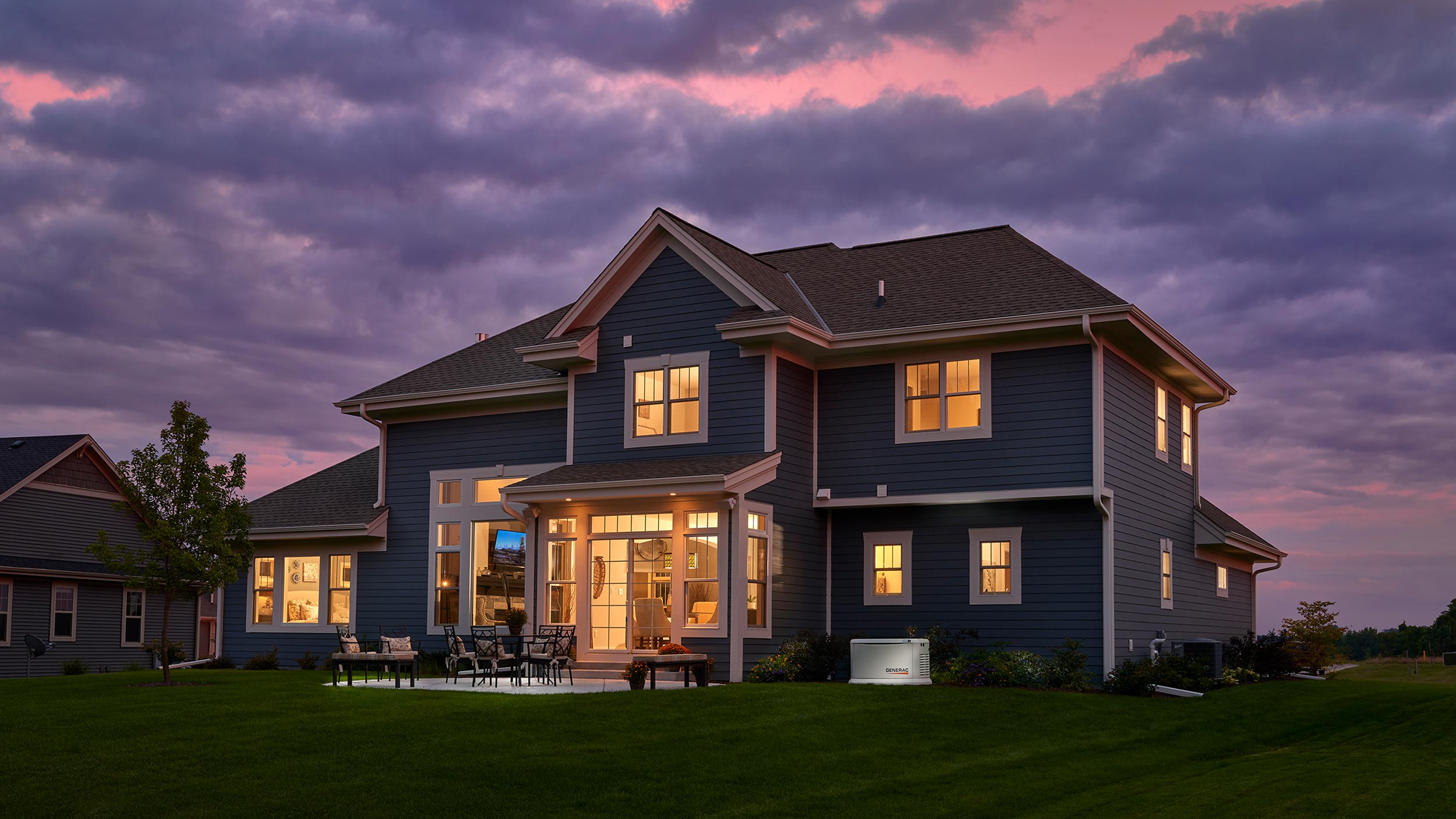 Generac standby generator beside a large home